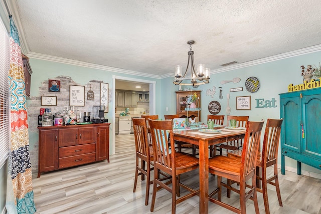 dining space with light wood finished floors, a notable chandelier, visible vents, and crown molding