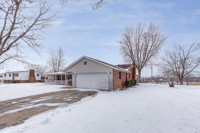 view of front of home featuring a garage, brick siding, a chimney, and a porch