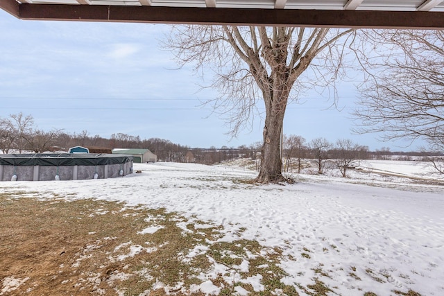 yard layered in snow featuring a covered pool