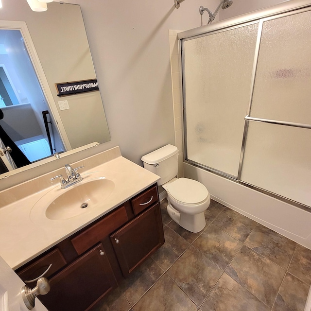 bathroom featuring toilet, shower / bath combination with glass door, and vanity