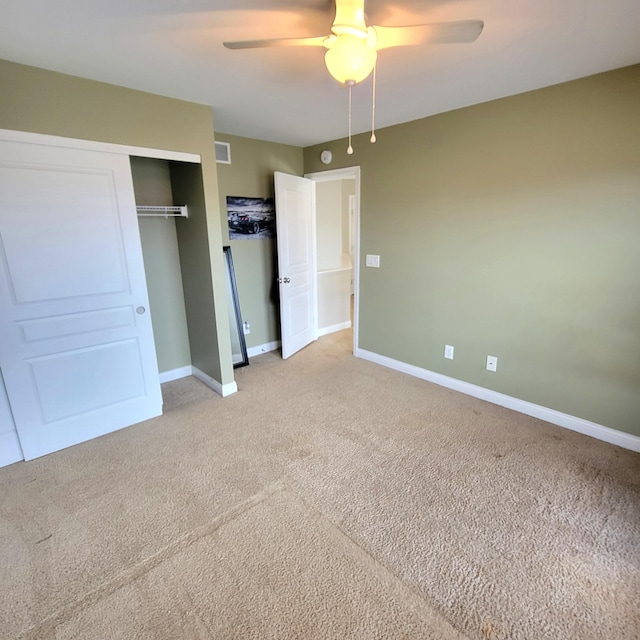 unfurnished bedroom featuring a closet, light carpet, ceiling fan, and baseboards