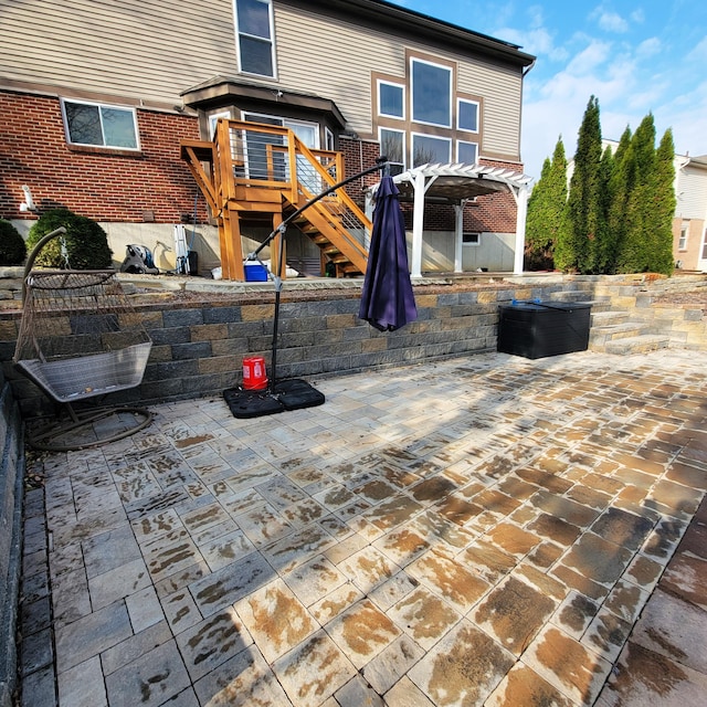 back of house featuring a patio area, stairway, a pergola, and brick siding