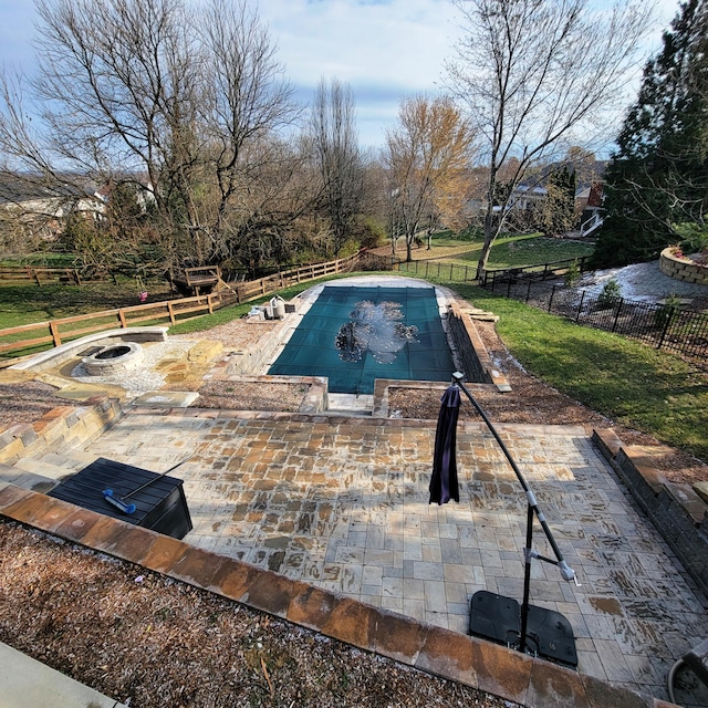 view of swimming pool with an outdoor fire pit, a fenced in pool, a lawn, a fenced backyard, and a patio area