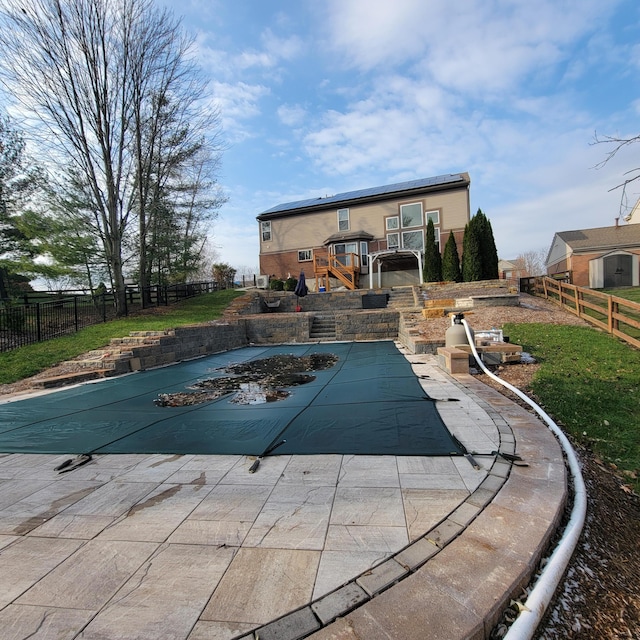 rear view of house with a patio area, a fenced backyard, and a fenced in pool