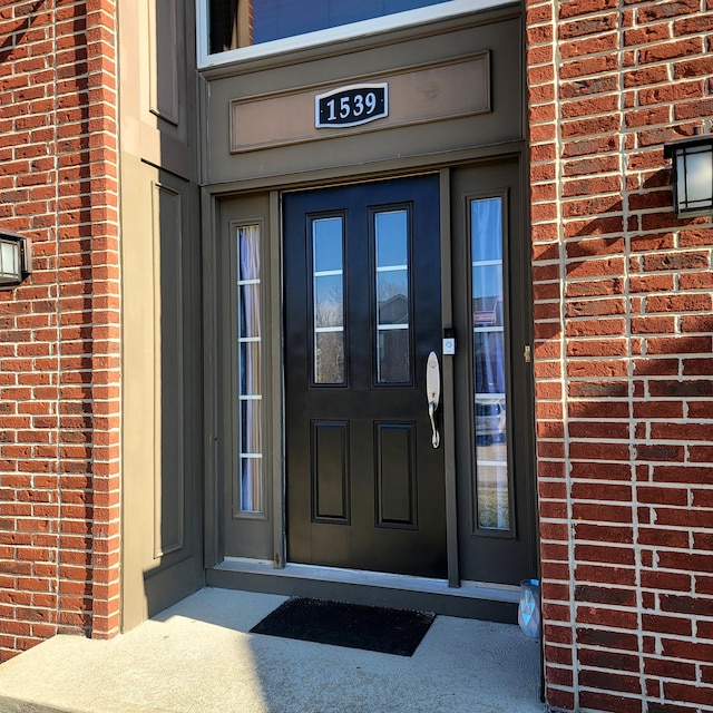 doorway to property featuring brick siding