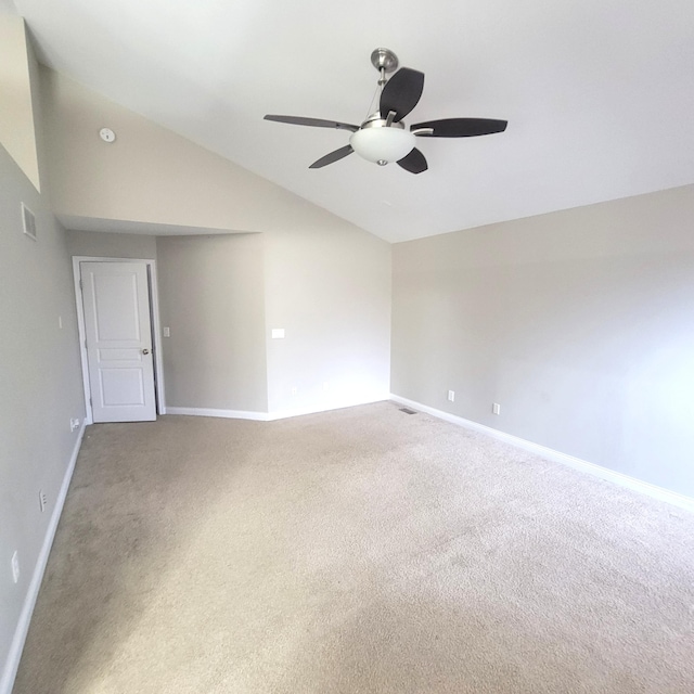 carpeted spare room with lofted ceiling, visible vents, a ceiling fan, and baseboards