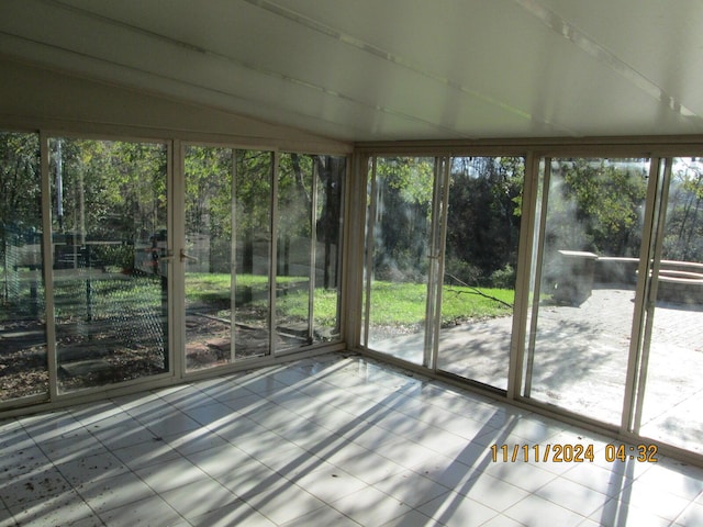 unfurnished sunroom with lofted ceiling