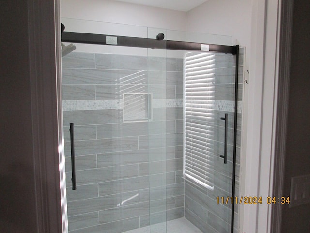 bathroom with a shower with door