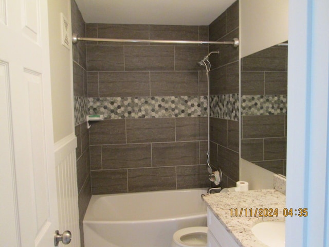 full bathroom with vanity, toilet, and tiled shower / bath