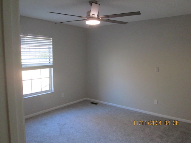 carpeted spare room featuring ceiling fan