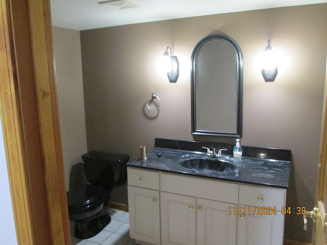 bathroom with tile patterned flooring, vanity, and toilet