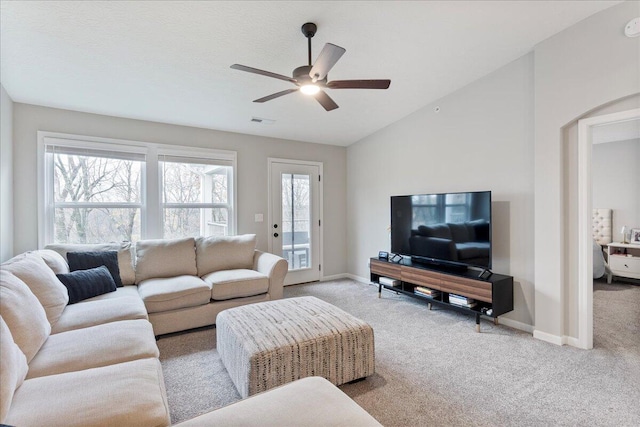 living room featuring plenty of natural light, ceiling fan, light colored carpet, and lofted ceiling