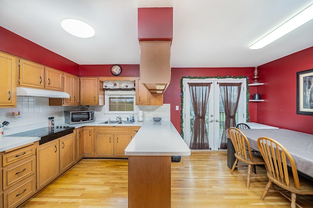 kitchen featuring french doors, sink, decorative backsplash, light hardwood / wood-style floors, and kitchen peninsula