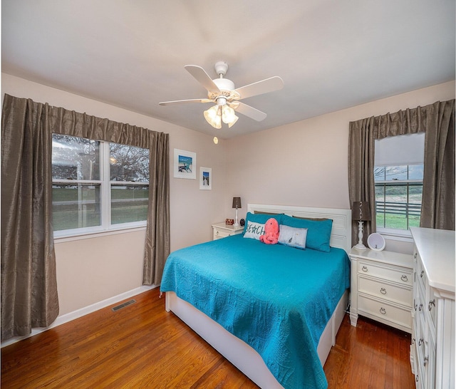 bedroom featuring multiple windows, ceiling fan, and dark wood-type flooring