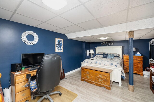 bedroom featuring a drop ceiling and light hardwood / wood-style floors