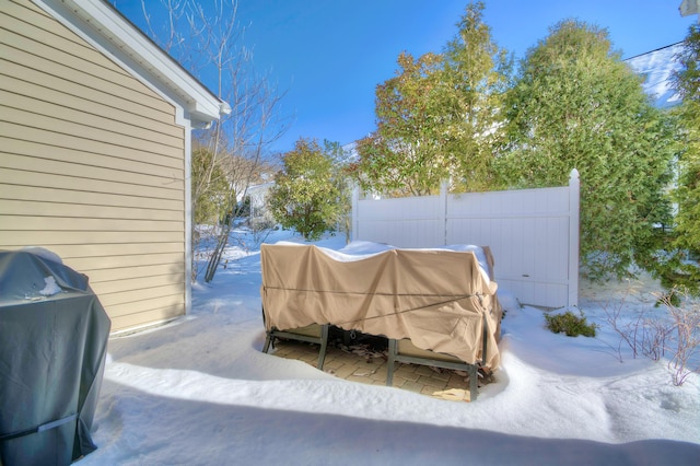 snow covered patio with a grill