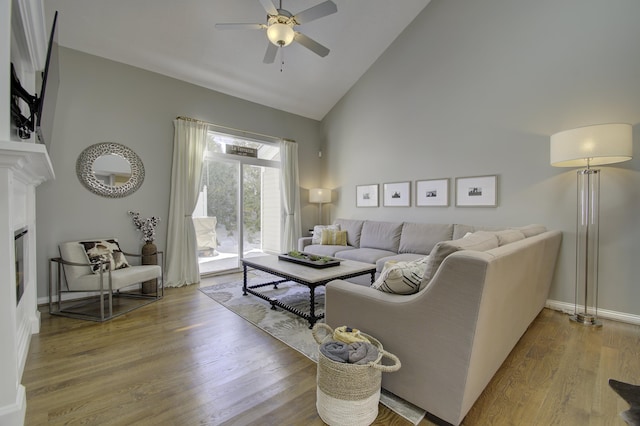 living room with wood-type flooring, high vaulted ceiling, and ceiling fan