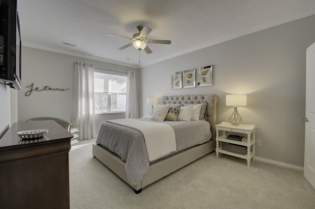 carpeted bedroom with ceiling fan, ornamental molding, and a textured ceiling