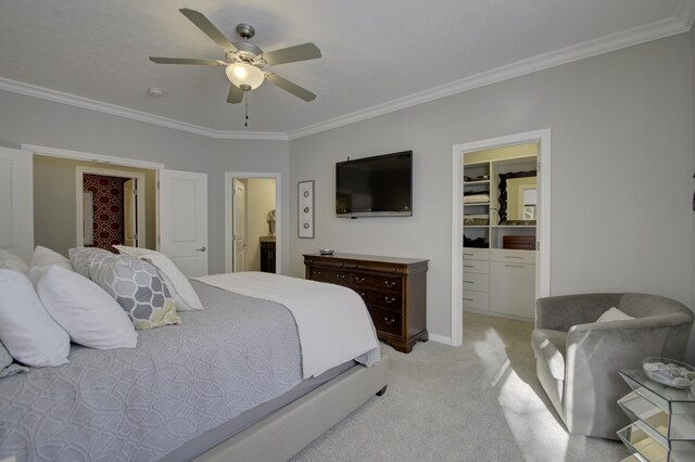 bedroom with ceiling fan, a spacious closet, ornamental molding, connected bathroom, and light colored carpet