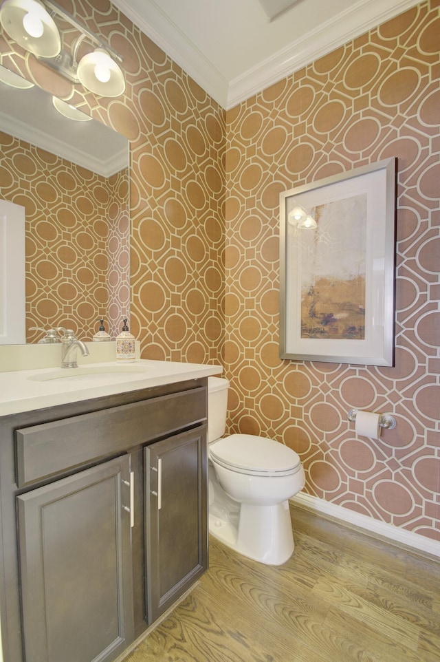 bathroom with hardwood / wood-style floors, vanity, toilet, and crown molding