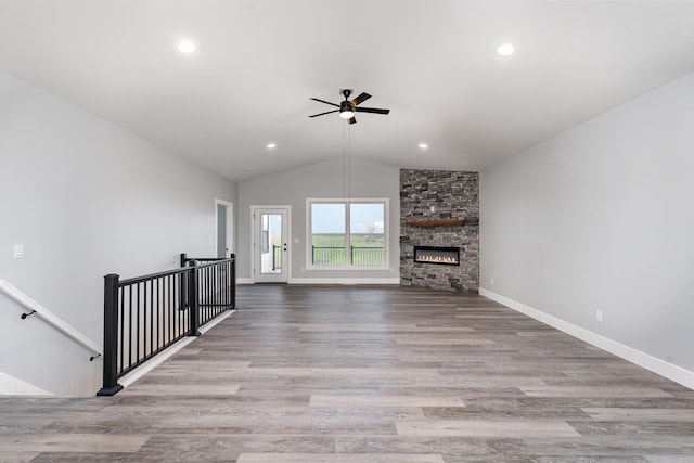 unfurnished living room with a fireplace, ceiling fan, light hardwood / wood-style flooring, and vaulted ceiling