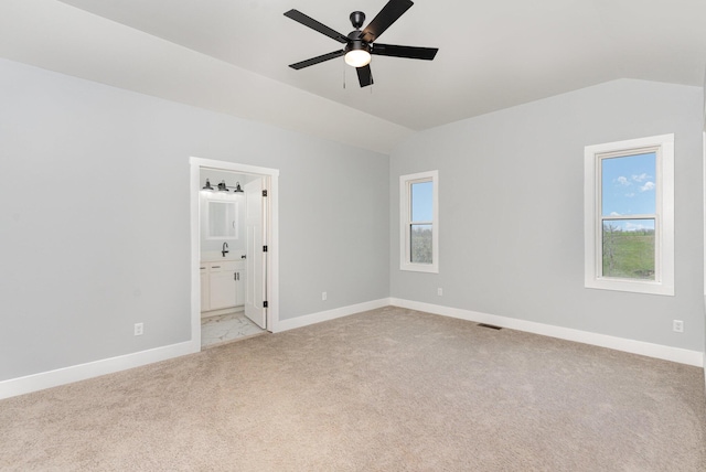 spare room with light carpet, vaulted ceiling, and ceiling fan