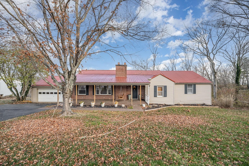 ranch-style house featuring covered porch and a garage