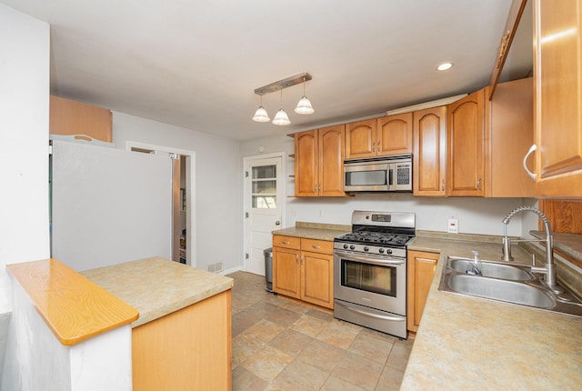 kitchen featuring sink, hanging light fixtures, a notable chandelier, and appliances with stainless steel finishes