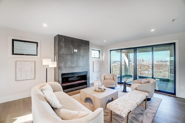 living room with a tile fireplace and light hardwood / wood-style flooring