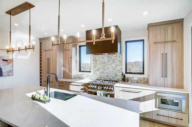 kitchen featuring sink, stainless steel appliances, tasteful backsplash, light stone counters, and decorative light fixtures