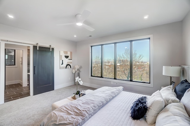 bedroom featuring a barn door and ceiling fan