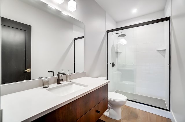 bathroom featuring hardwood / wood-style floors, vanity, toilet, and an enclosed shower