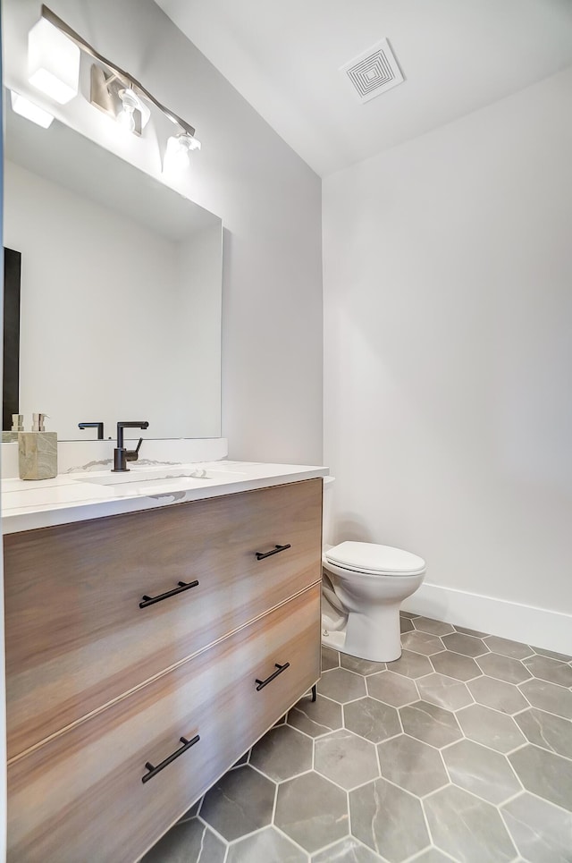 bathroom featuring tile patterned flooring, vanity, and toilet