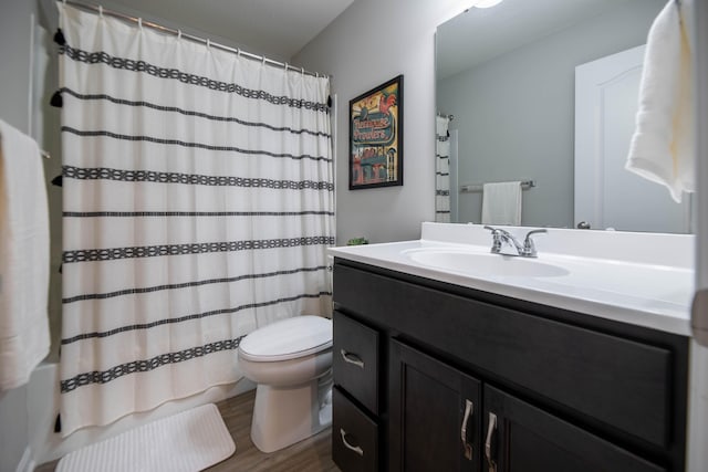 full bathroom with hardwood / wood-style floors, vanity, shower / bath combination with curtain, and toilet