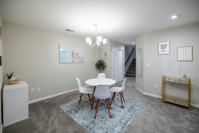 carpeted dining room with a chandelier