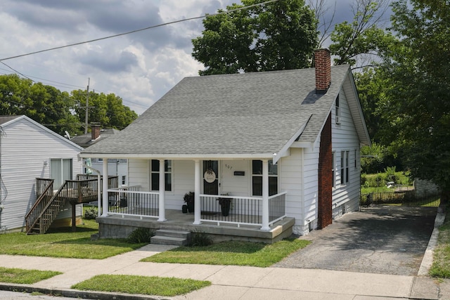 bungalow-style house with a porch and a front lawn