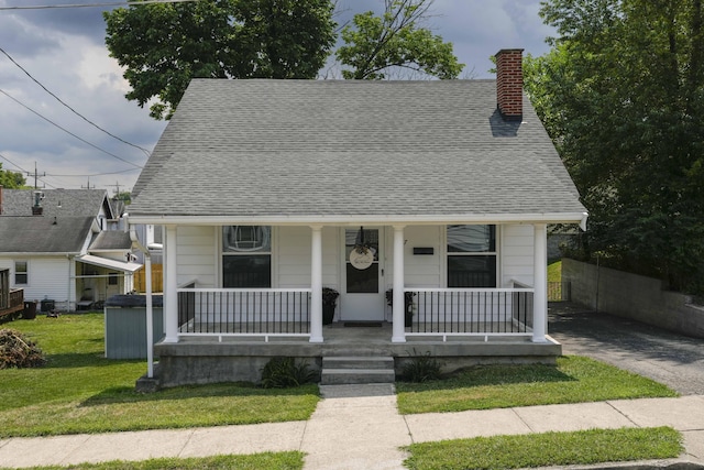 bungalow with a front yard and covered porch