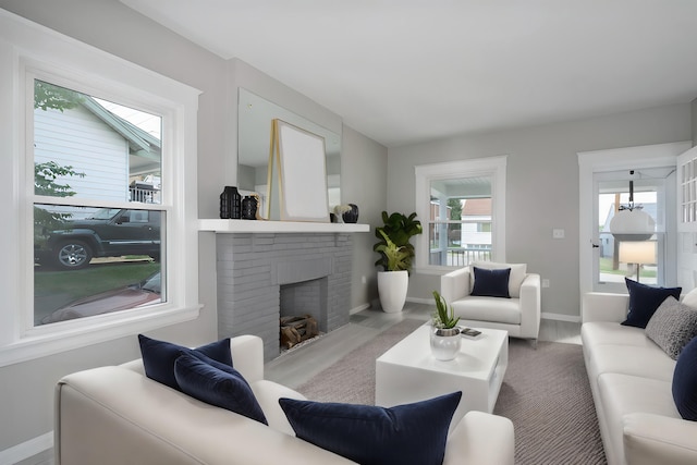 living room featuring a brick fireplace and a wealth of natural light