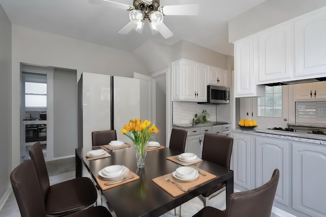 kitchen featuring white cabinets, decorative backsplash, white gas cooktop, and plenty of natural light