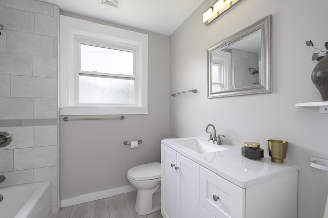 full bathroom featuring vanity, hardwood / wood-style flooring, toilet, and tiled shower / bath combo