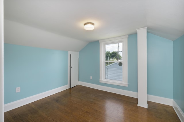 additional living space with dark hardwood / wood-style flooring and vaulted ceiling