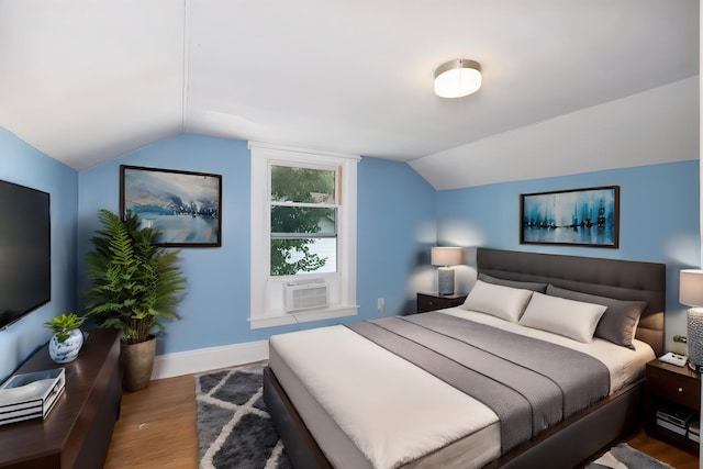 bedroom featuring wood-type flooring, vaulted ceiling, and cooling unit