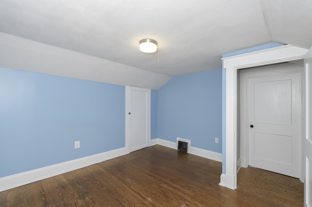 bonus room featuring dark wood-type flooring and lofted ceiling