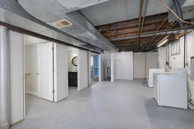 basement featuring independent washer and dryer and sink