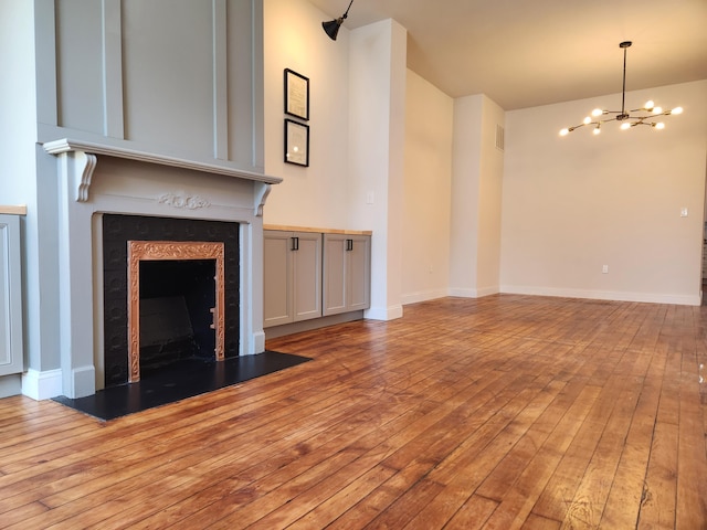 unfurnished living room featuring light wood-type flooring and an inviting chandelier