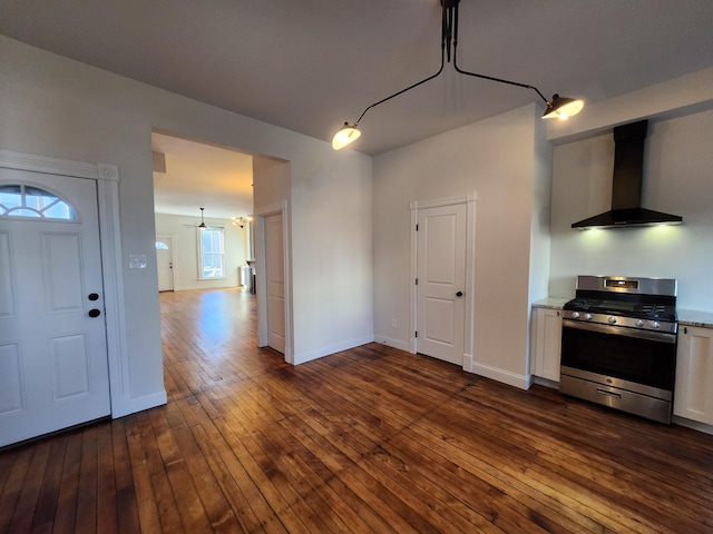 kitchen featuring white cabinets, wall chimney range hood, ceiling fan, stainless steel range, and dark hardwood / wood-style flooring