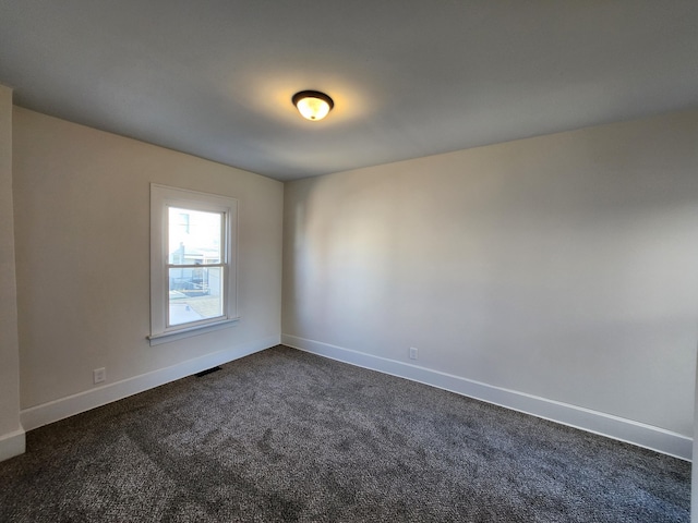 empty room featuring dark carpet