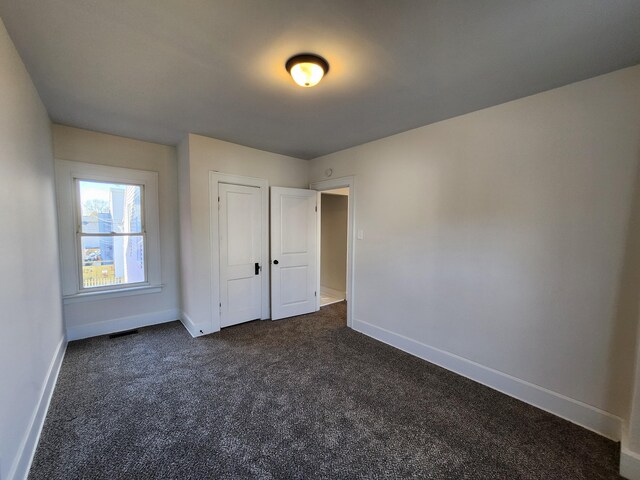 927 Boone St, Newport, KY 41071 - unfurnished bedroom featuring dark carpet, baseboards, and a closet