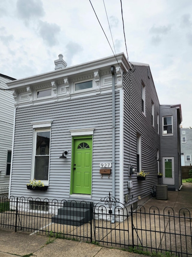 view of front facade with a fenced front yard and a chimney