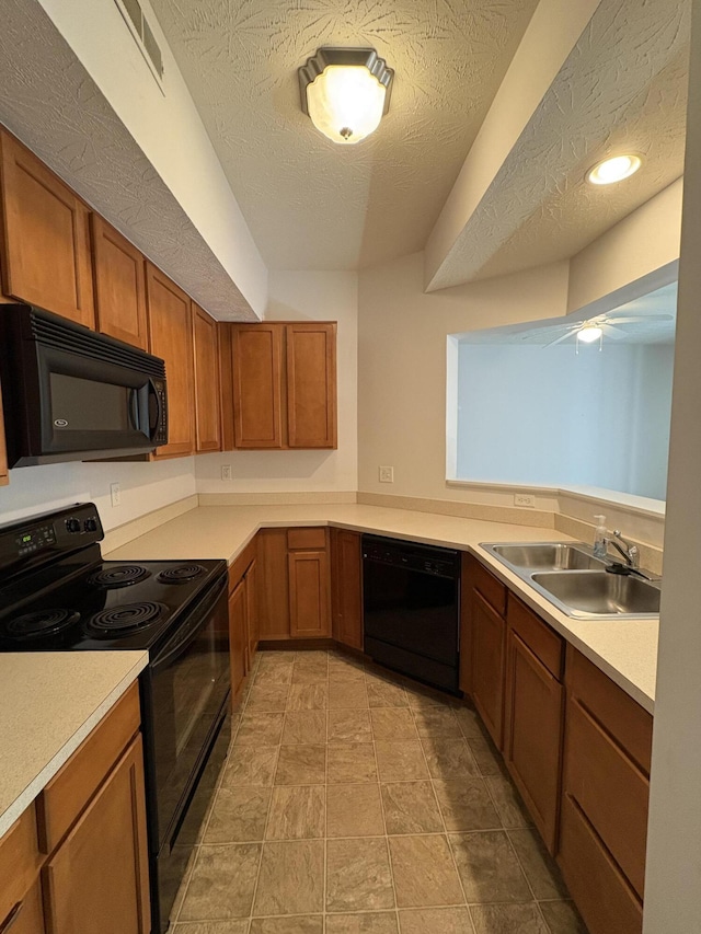 kitchen featuring a textured ceiling, sink, and black appliances